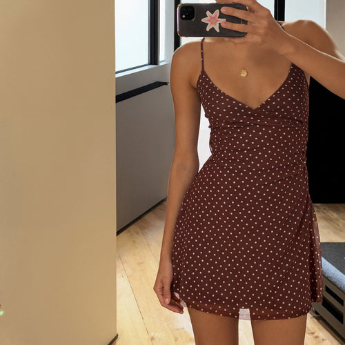 Brown slip dress with white polka dots, spaghetti straps, and a V-neckline.