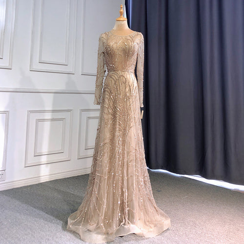 Beige long-sleeve evening gown with intricate sparkly beaded patterns on a mannequin.