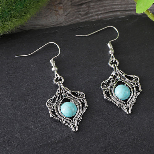 Silver hook earrings featuring a twisted wire frame with a central turquoise gemstone bead.