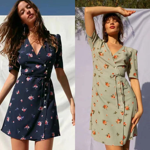 Two models wearing short-sleeved, V-neck wrap dresses with floral patterns, one navy blue, one light green.