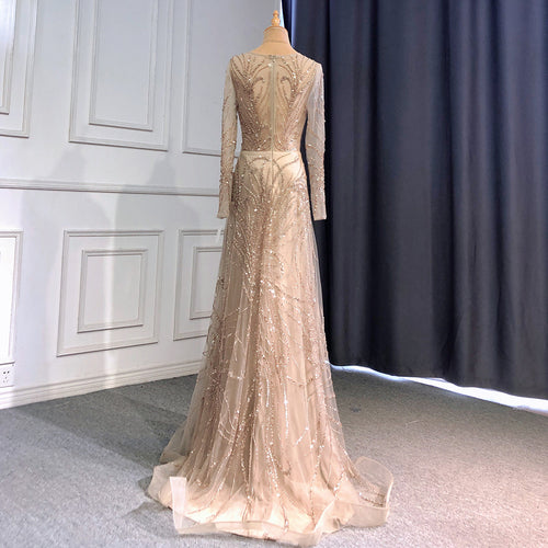 Long-sleeve, floor-length beige evening gown with intricate gold sequin embroidery on a mannequin, seen from behind.