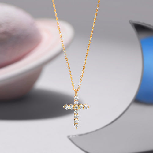 Gold chain necklace with a cross-shaped pendant encrusted with small round diamonds.