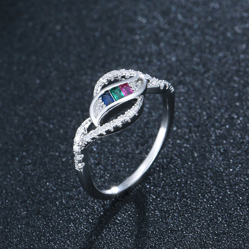 Silver ring with pavé-set clear zircons framing three rectangular blue, green, and red stones.