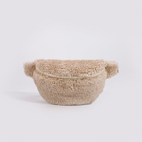 Beige fuzzy fleece fanny pack with a zipper closure, shown against a plain background.